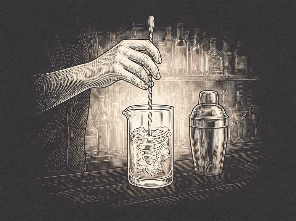 Una mano removiendo con cucharilla en un vaso mezclador, junto a la coctelera, grabado