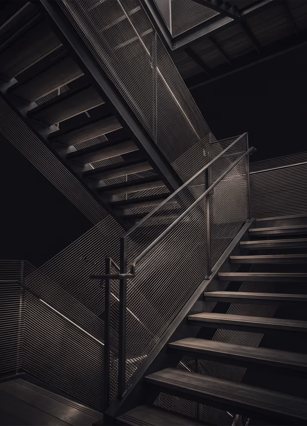 Una escalera abierta con varios tramos que se cruzan, en grabado.